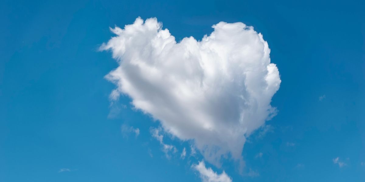 een wolk tegen een blauwe lucht in de vorm van een hart