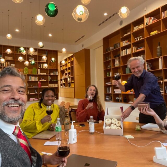 mensen aan een groot bureau in een kantoor met taartjes