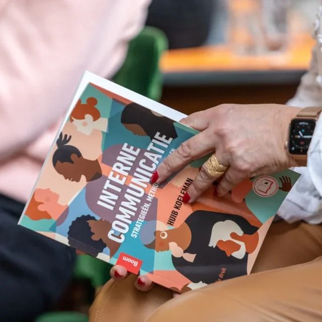 Persoon leest boek Interne Communicatie door Huib Koeleman