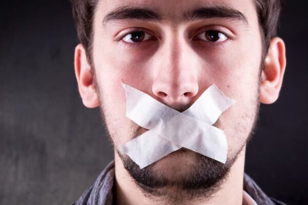 man met tape op ziojn mond. Spreek je uit! Zo versterk je sociale veiligheid via communicatie