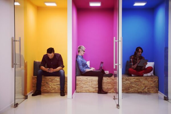 drie mensen die naast elkaar alleen naar hun telefoon of ipad kijken