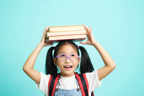 een meisje met een boek op haar hoofd