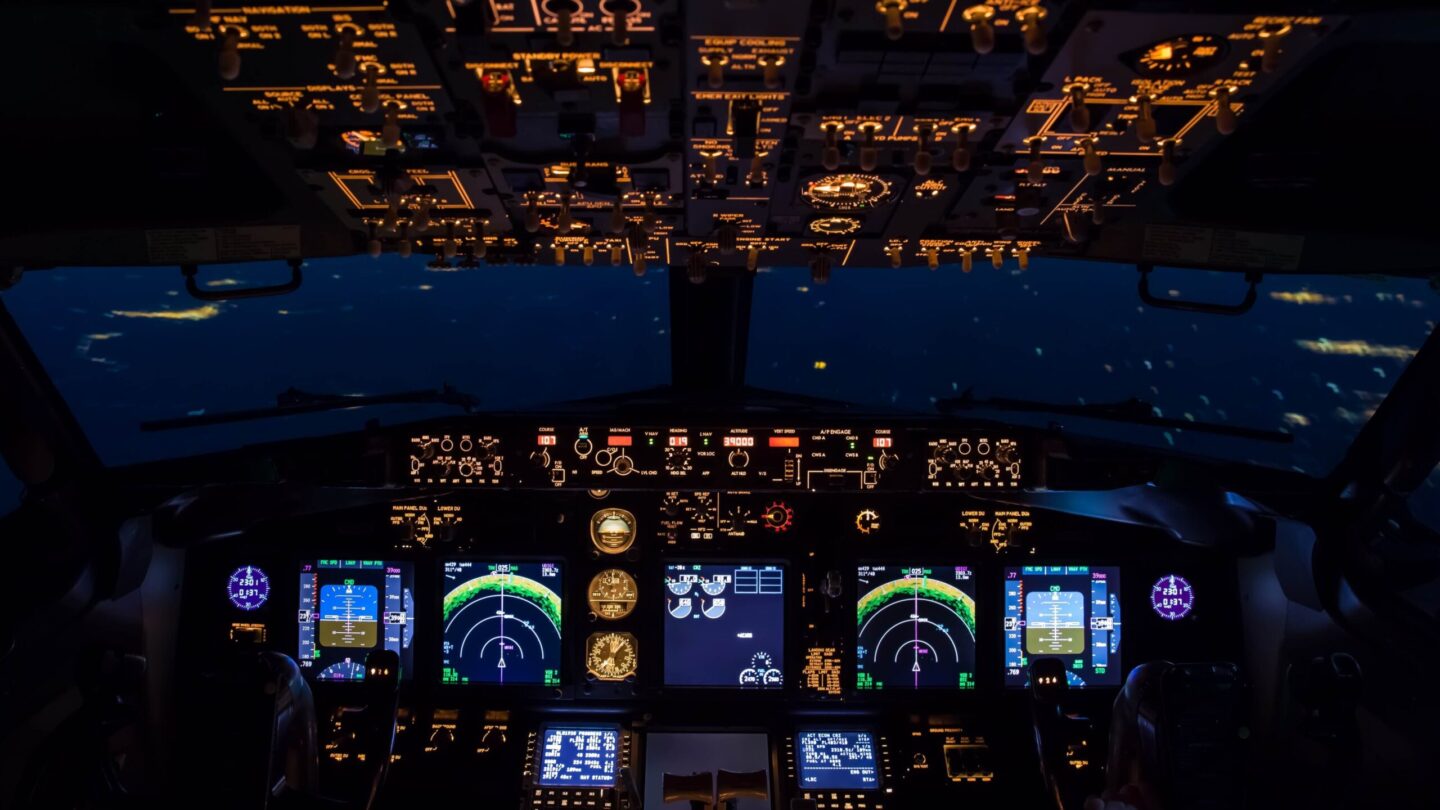 je ziet een cockpit van een vliegtuig bij avond